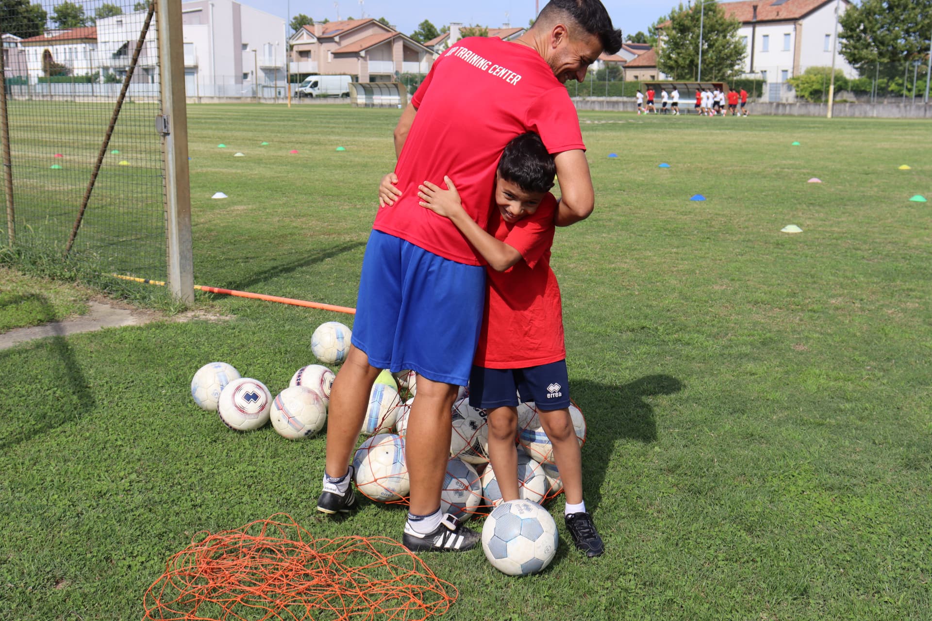 Orlando Pasetto abbraccia un giovane allievo a bordo campo durante l'allenamento